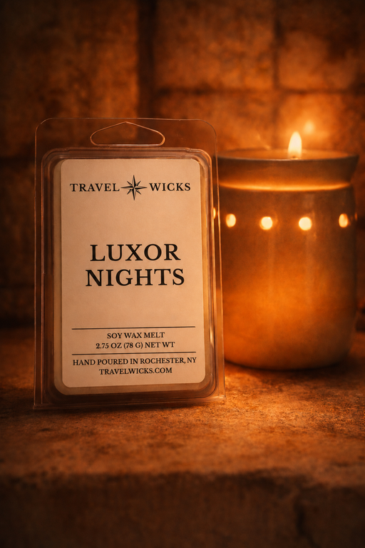 Travel Wicks Luxor Nights soy wax melt package with a lit candle in the background.